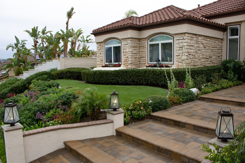 This is an example of a large mediterranean full sun front yard concrete paver landscaping in Orange County.