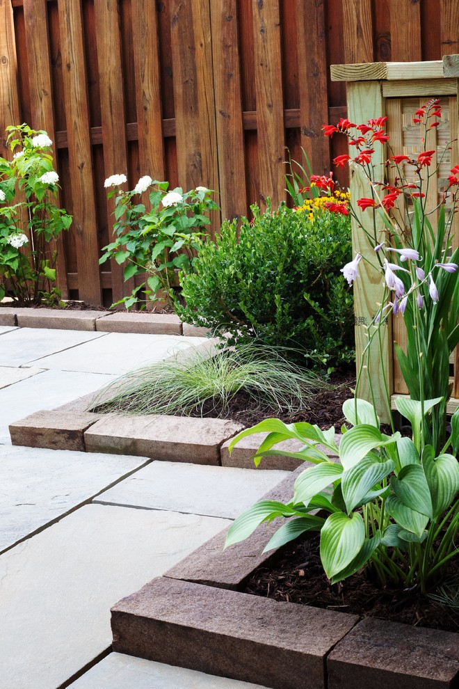 Immagine di un piccolo giardino moderno esposto a mezz'ombra dietro casa in estate con pavimentazioni in pietra naturale