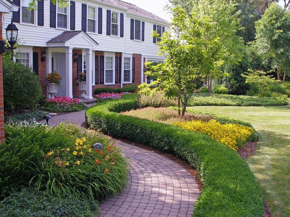 Источник вдохновения для домашнего уюта: участок и сад на переднем дворе в классическом стиле с мощением клинкерной брусчаткой и клумбами