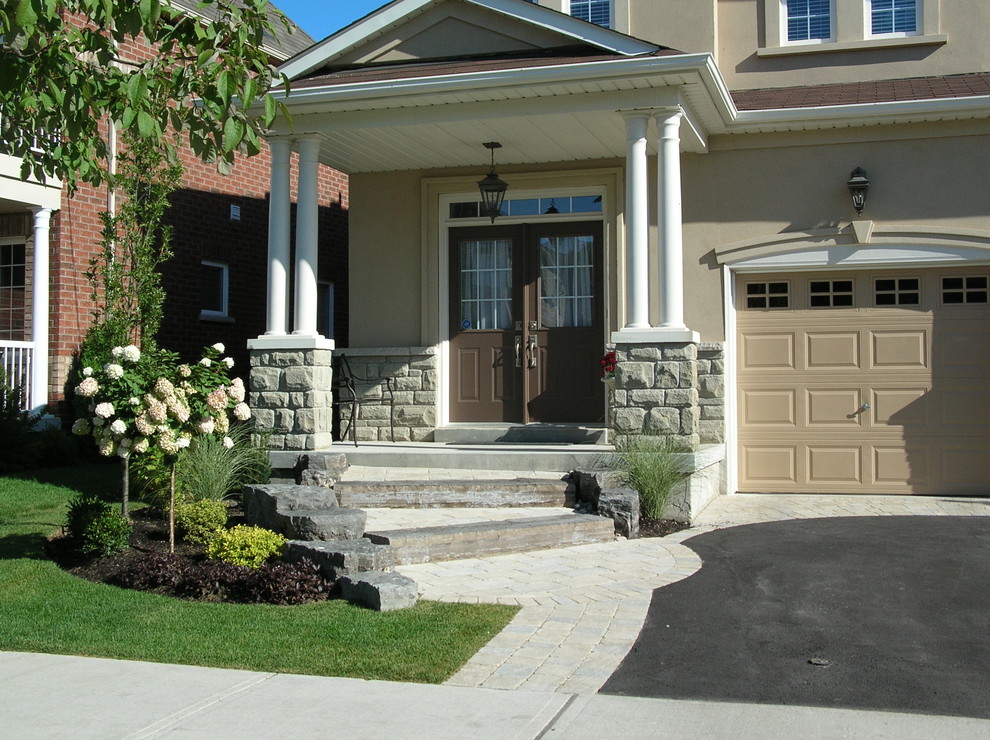 Photo of a mid-sized transitional full sun front yard concrete paver garden path in Toronto.