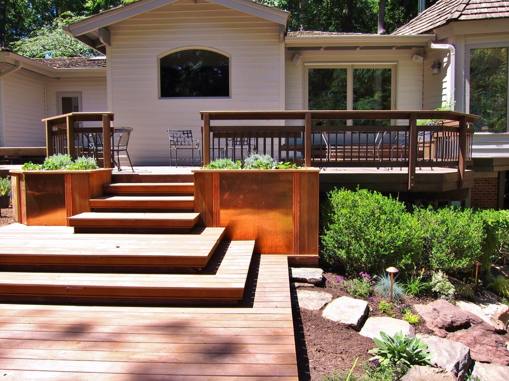 Cette image montre un grand jardin potager arrière chalet avec une exposition ensoleillée et une terrasse en bois.