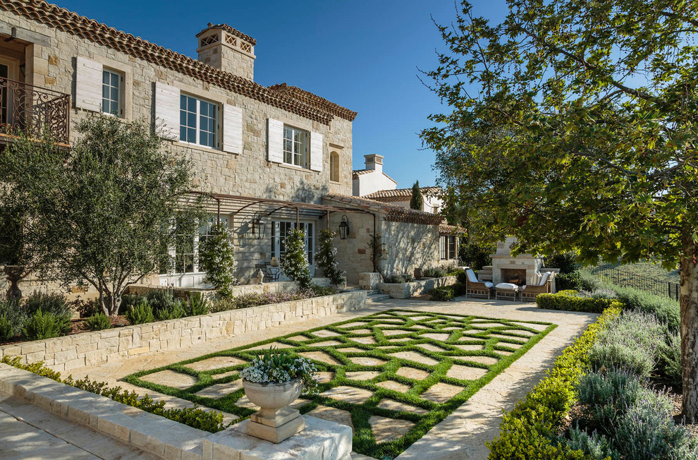Inspiration for a mediterranean garden in Orange County with natural stone paving and a fireplace.