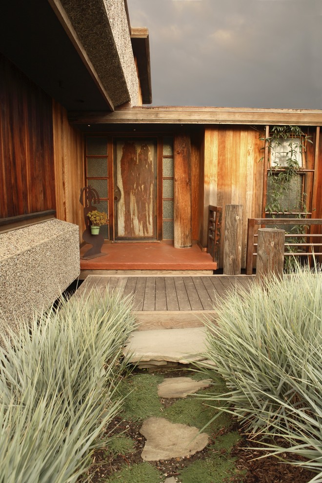 Cette image montre un jardin avant bohème avec une terrasse en bois.