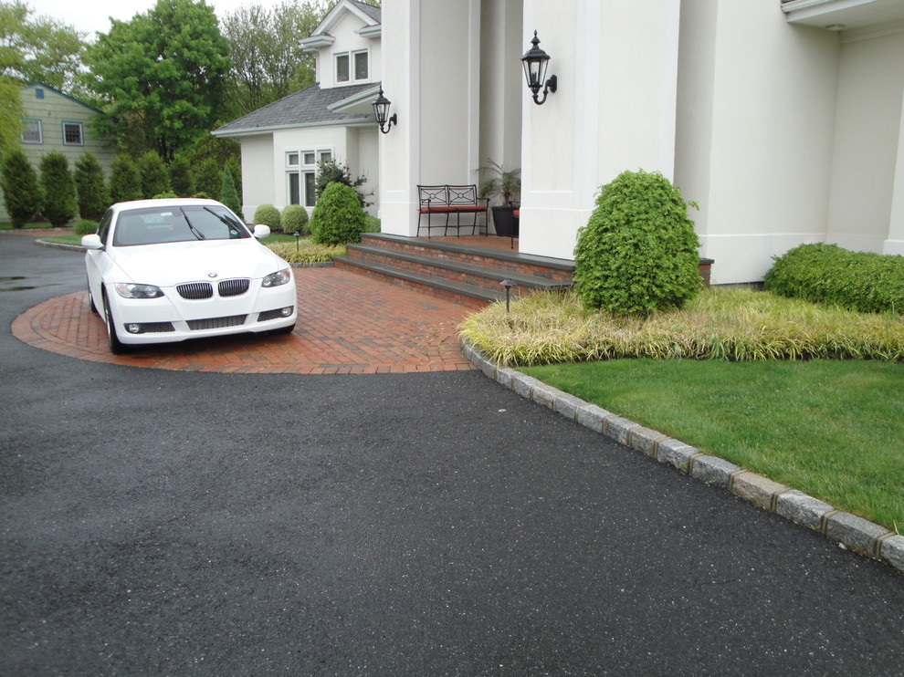 Inspiration for a large contemporary full sun front yard brick driveway in New York.