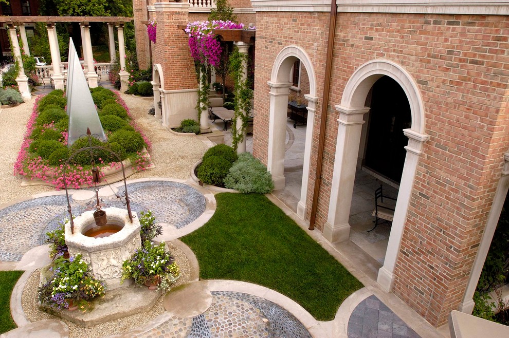 Idee per un ampio giardino formale tradizionale in cortile in estate con pavimentazioni in pietra naturale