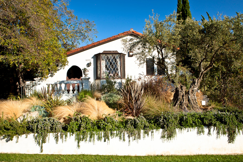 This is an example of a mediterranean front yard retaining wall landscape in Los Angeles.
