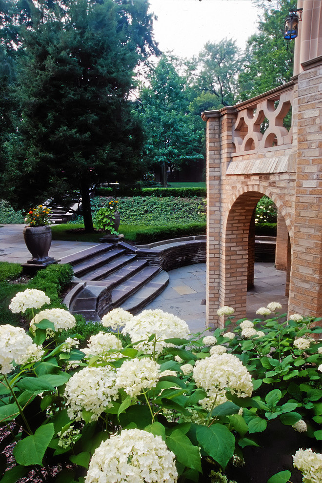 Photo of a large mediterranean partial sun backyard stone landscaping in Chicago for summer.