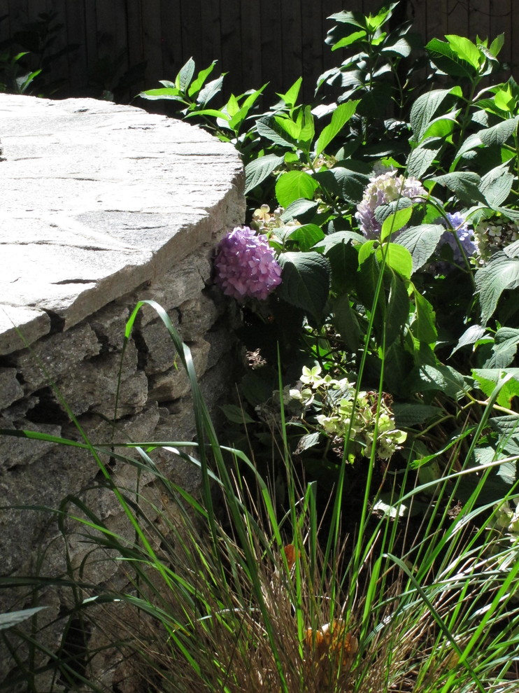 Idée de décoration pour un petit jardin arrière design avec une exposition partiellement ombragée et des pavés en pierre naturelle.