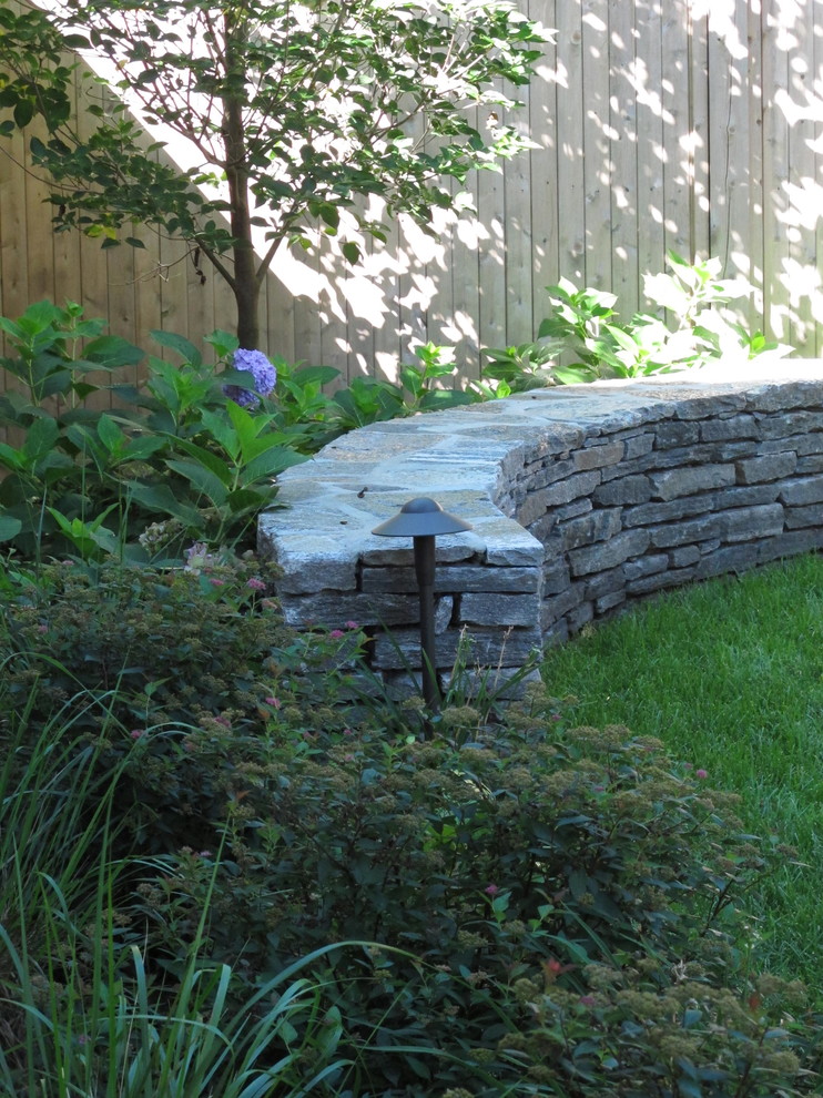 Photo of a small contemporary partial sun backyard stone landscaping in Boston.