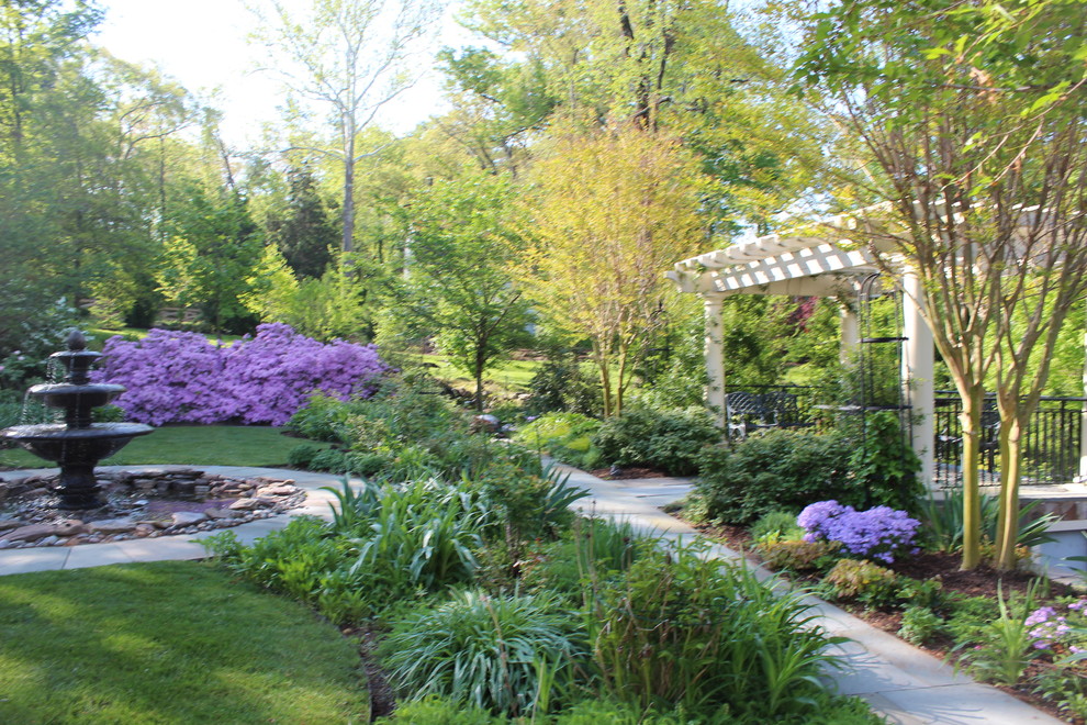 Diseño de jardín tradicional extra grande en primavera en patio lateral con jardín francés, fuente, exposición total al sol y adoquines de piedra natural