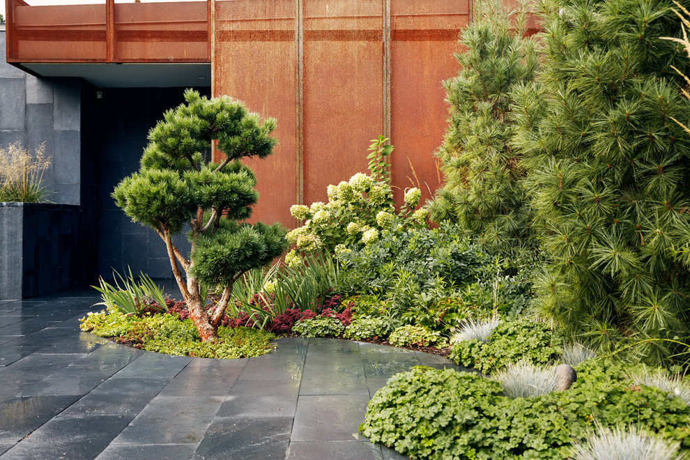 Diseño de jardín contemporáneo de tamaño medio en verano en patio delantero con fuente, exposición parcial al sol y adoquines de piedra natural