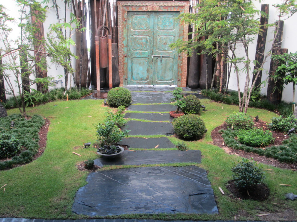 Photo of a medium sized world-inspired front fully shaded garden in Miami with a garden path.