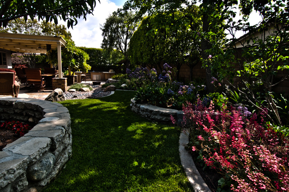 Modelo de jardín de estilo zen pequeño en primavera en patio trasero con muro de contención, exposición parcial al sol y piedra decorativa