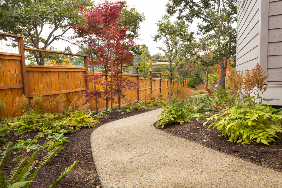 Medium sized classic back fully shaded garden in Other with a garden path and gravel.