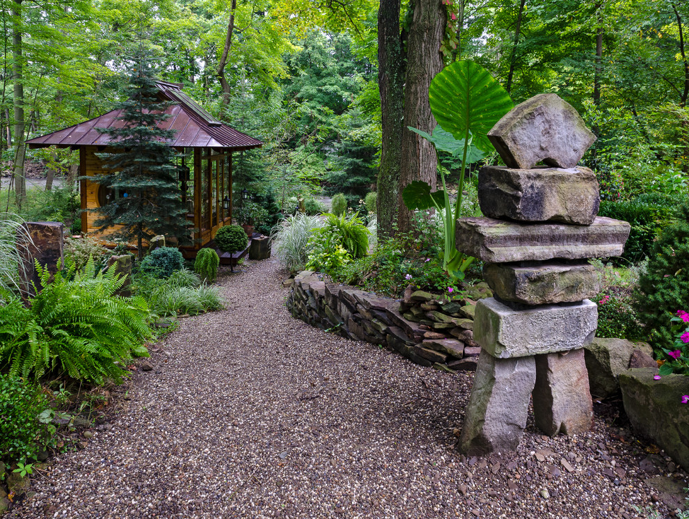 Photo of a medium sized world-inspired back partial sun garden in Cleveland with gravel.