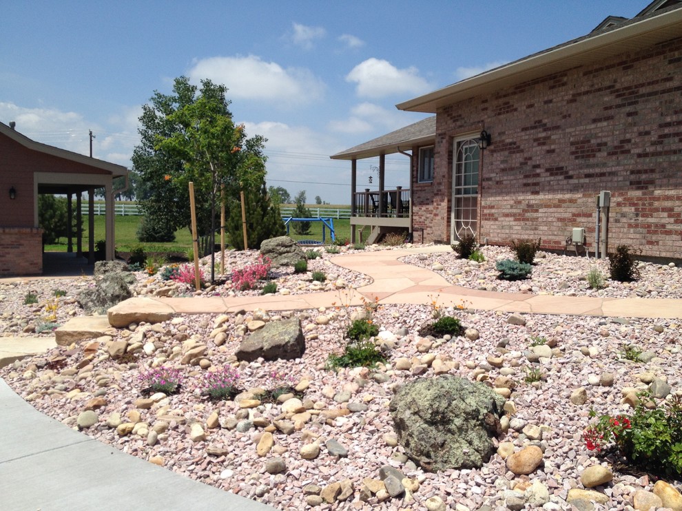 Пример оригинального дизайна: солнечный засухоустойчивый сад среднего размера на склоне в стиле кантри с подпорной стенкой, хорошей освещенностью и покрытием из каменной брусчатки