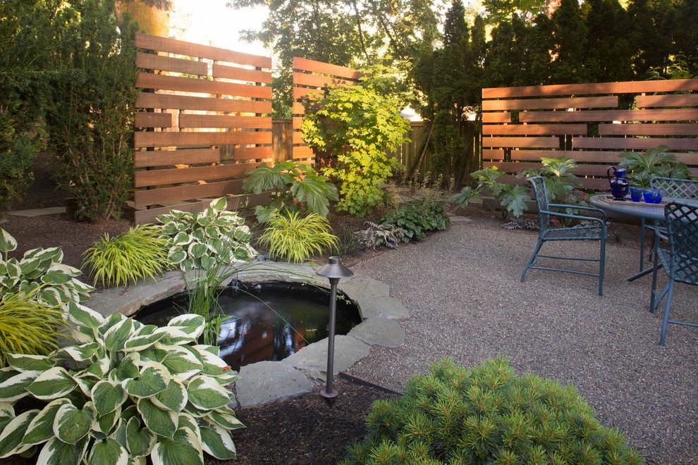 Bild på en mellanstor funkis trädgård i delvis sol, med marksten i betong och en damm