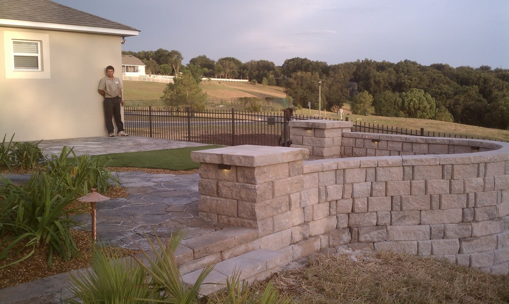 This is an example of a mid-sized traditional backyard stone landscaping in Orlando.