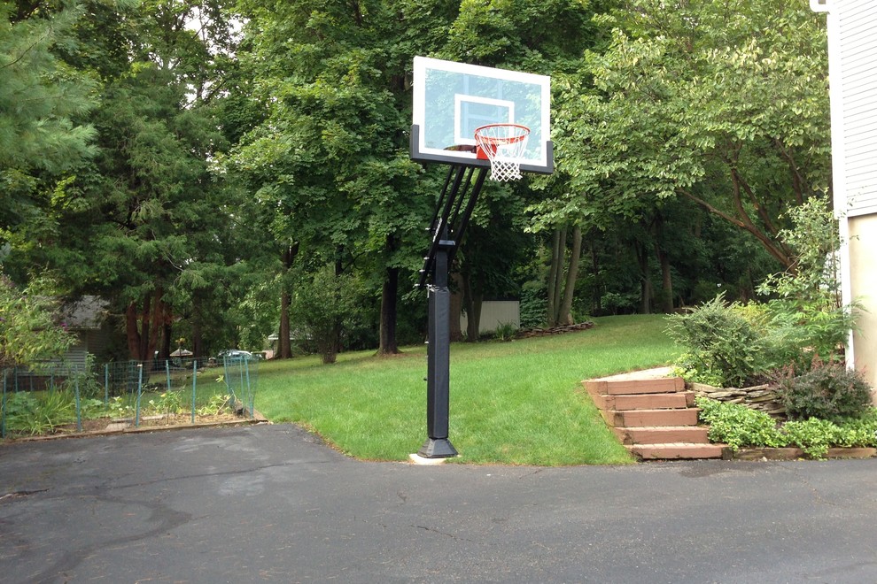 Large classic back partial sun garden in Philadelphia with an outdoor sport court.