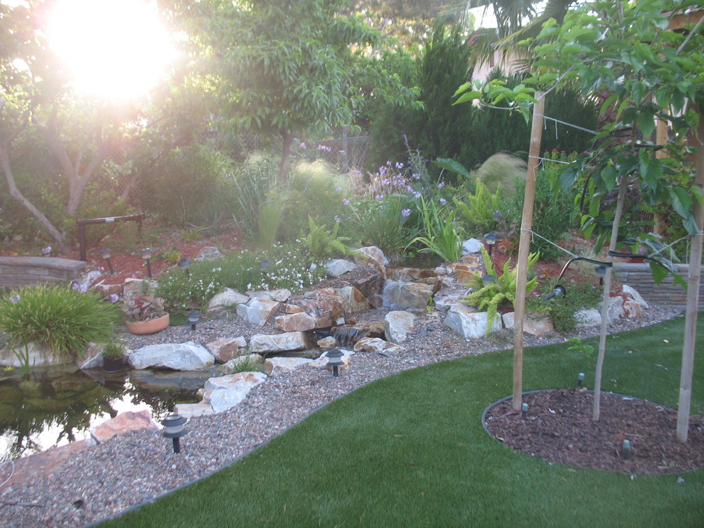 Medium sized rustic back formal full sun garden for autumn in Los Angeles with a water feature and decking.