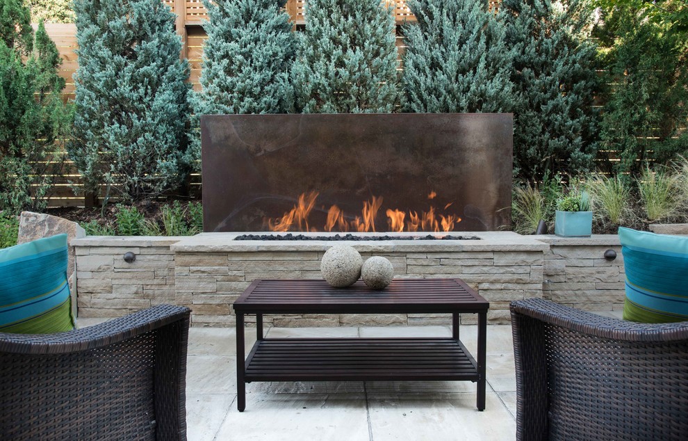 Inspiration for a mid-sized contemporary backyard stone patio remodel in Denver with a fire pit