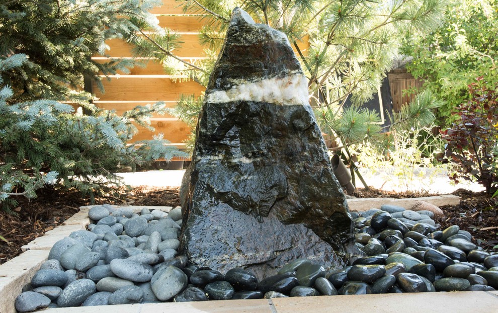 Imagen de jardín actual de tamaño medio en patio trasero con brasero y adoquines de piedra natural