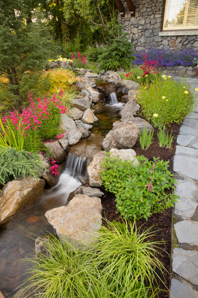 This is an example of a large classic garden in Portland with a pond.