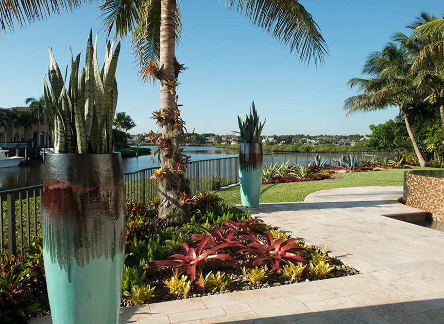Свежая идея для дизайна: большой солнечный участок и сад на заднем дворе в морском стиле с растениями в контейнерах, хорошей освещенностью и покрытием из каменной брусчатки - отличное фото интерьера
