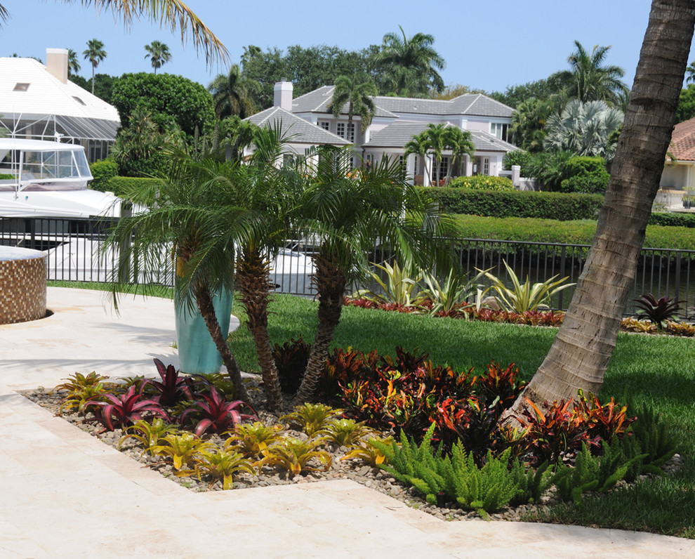 Exemple d'un grand jardin arrière exotique avec une exposition partiellement ombragée et des pavés en pierre naturelle.