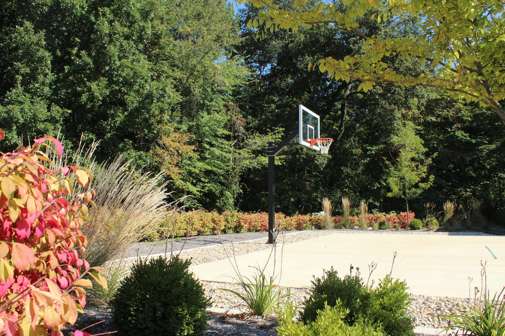 Large classic back partial sun garden in Indianapolis with an outdoor sport court and concrete paving.