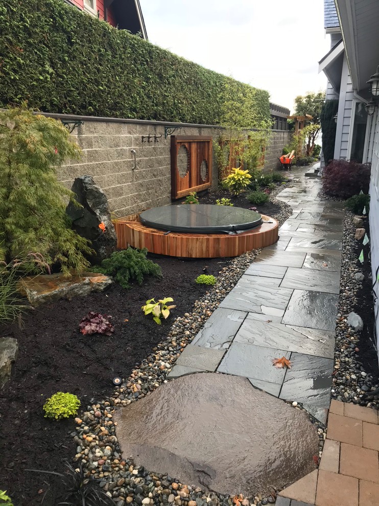 Photo of a mid-sized craftsman full sun backyard stone landscaping in Vancouver for spring.
