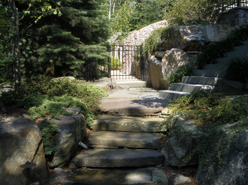 This is an example of a mid-sized mediterranean shade hillside stone garden path in New York.