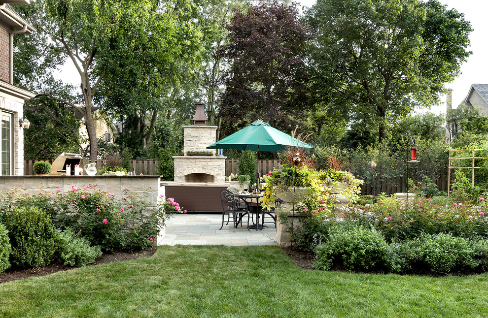 Aménagement d'un jardin arrière classique avec une exposition ensoleillée et des pavés en pierre naturelle.