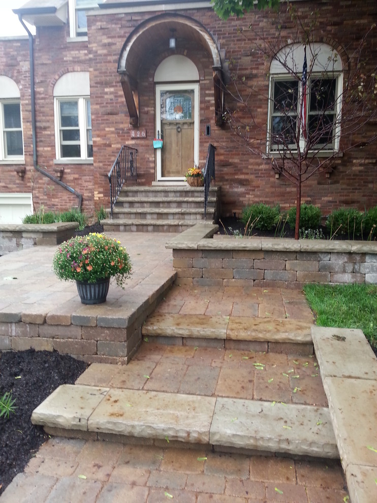 This is an example of a mid-sized traditional partial sun front yard brick landscaping in Chicago for spring.