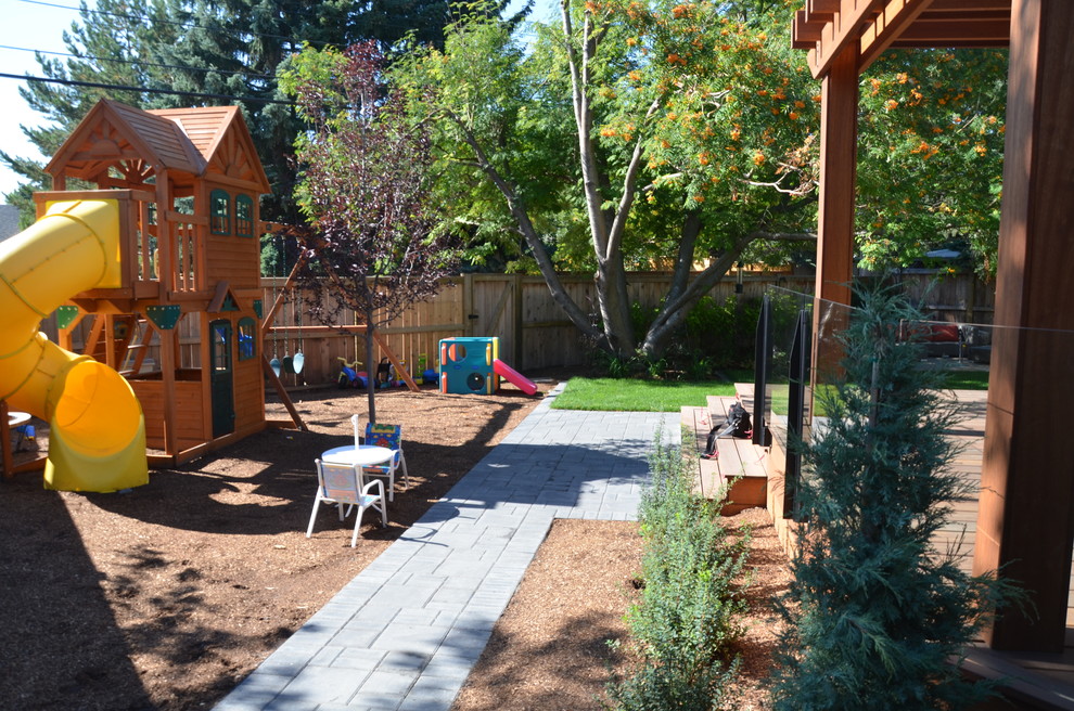 This is an example of a medium sized classic back partial sun garden for summer in Calgary with a garden path and decking.