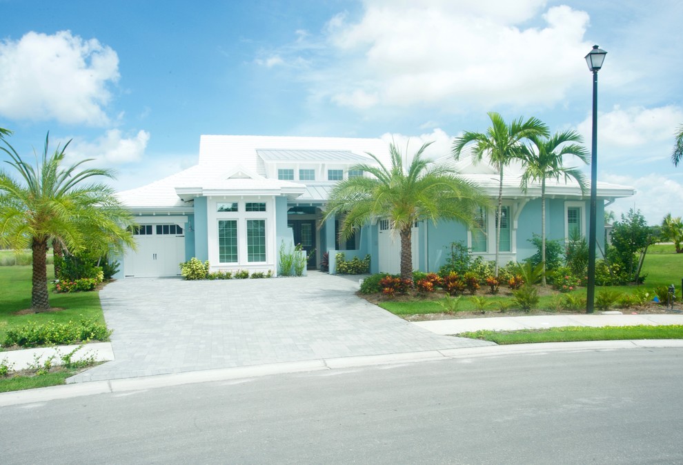 Ispirazione per un vialetto d'ingresso tropicale esposto in pieno sole davanti casa e di medie dimensioni con pavimentazioni in cemento