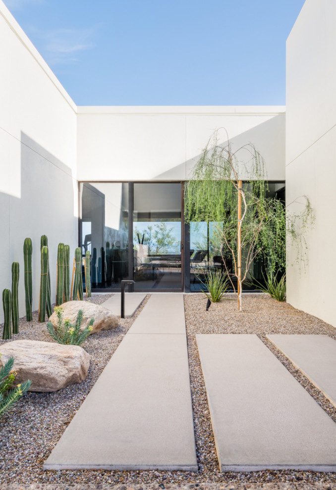 Diseño de jardín de secano minimalista de tamaño medio en patio lateral con paisajismo estilo desértico, exposición parcial al sol y adoquines de hormigón
