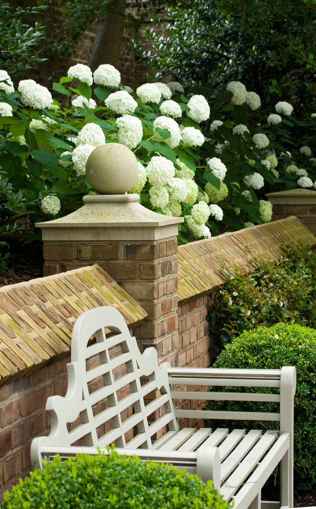 Idée de décoration pour un très grand jardin tradition avec un mur de soutènement et des pavés en pierre naturelle.