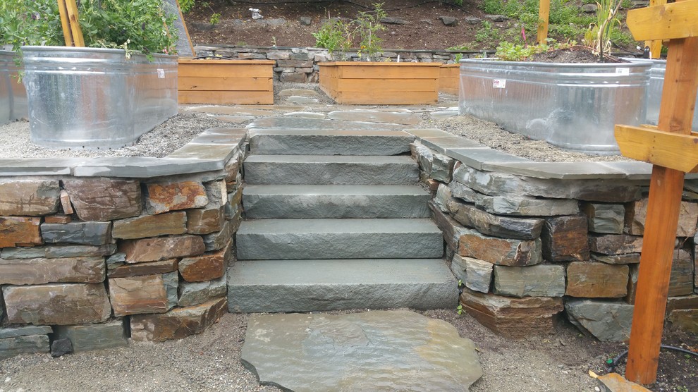 This is an example of a medium sized farmhouse back formal partial sun garden for summer in Seattle with a vegetable patch and natural stone paving.
