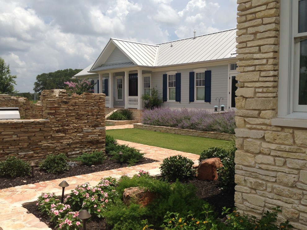 Photo of a mid-sized farmhouse full sun courtyard brick landscaping in Houston for summer.