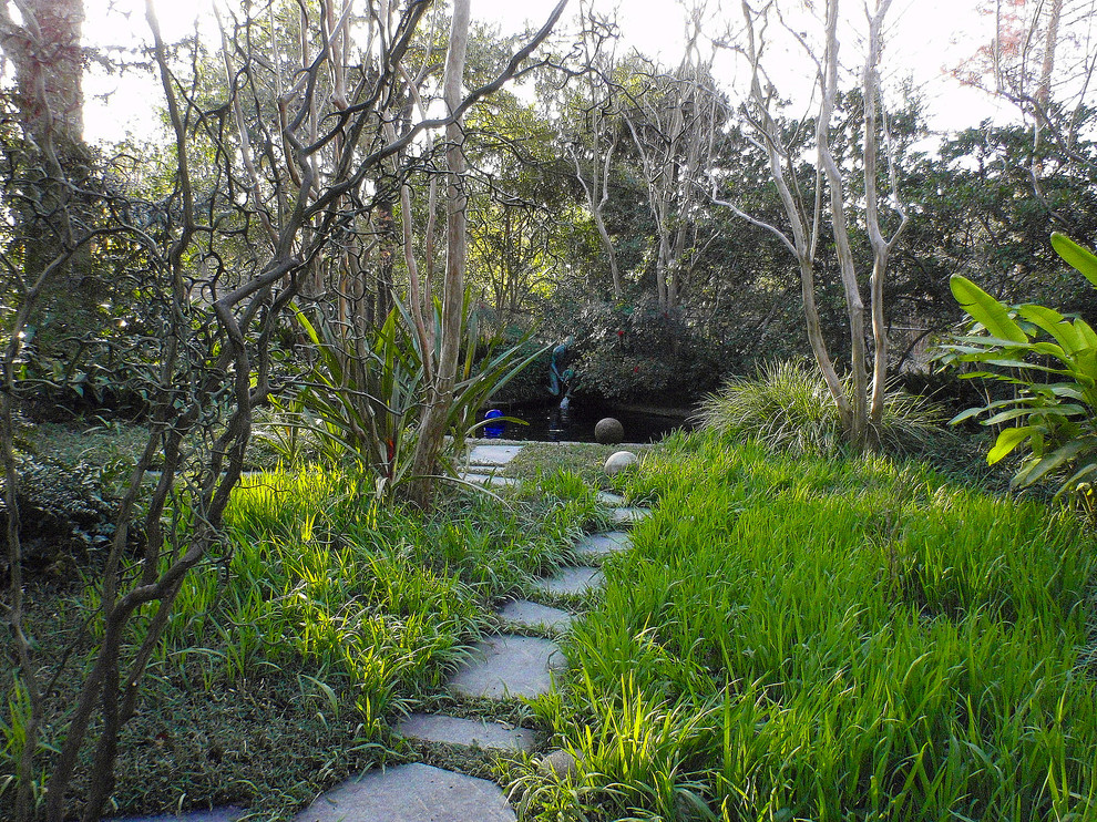 Cette image montre un aménagement d'entrée ou allée de jardin arrière traditionnel de taille moyenne avec des pavés en pierre naturelle.