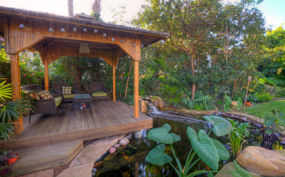 サンディエゴにある広いトロピカルスタイルのおしゃれな裏庭 (池、日陰、デッキ材舗装) の写真