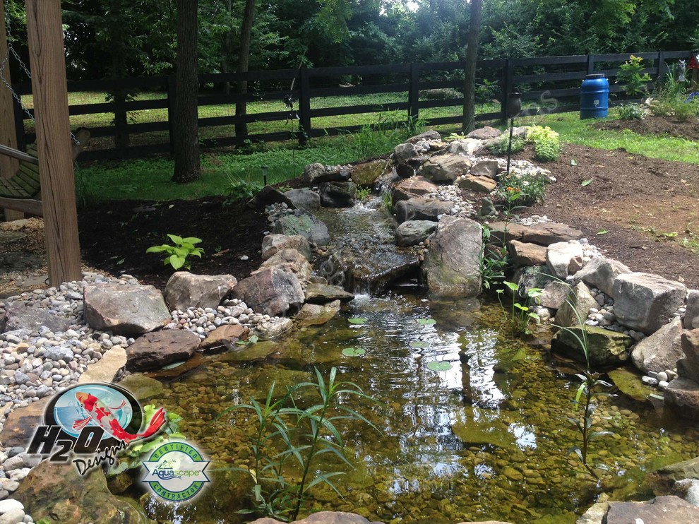 Cette photo montre un grand jardin arrière chic avec un bassin, une exposition ensoleillée et un paillis.