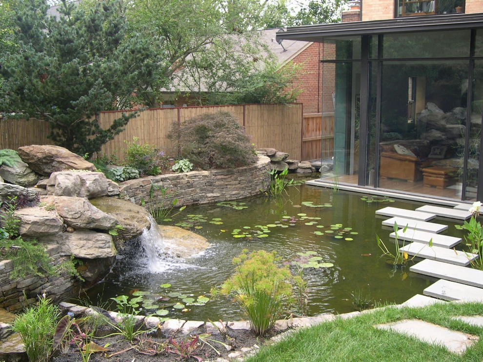 Imagen de jardín clásico renovado grande en patio trasero con adoquines de hormigón y estanque