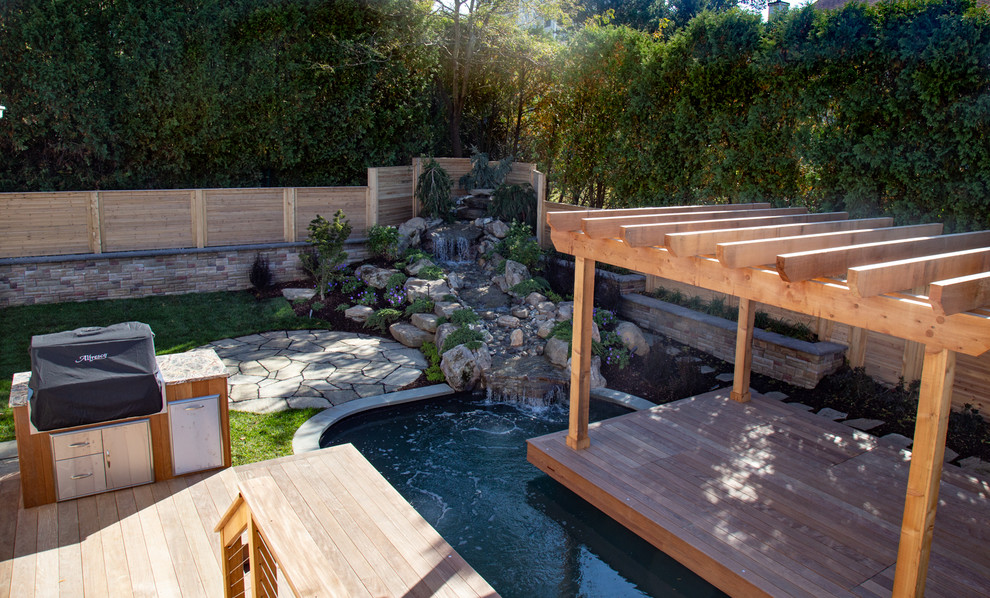 Réalisation d'un petit jardin arrière tradition avec un bassin et des pavés en pierre naturelle.