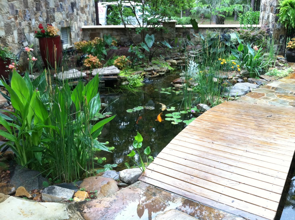 Modern back formal partial sun garden for spring in Charleston with a water feature and natural stone paving.