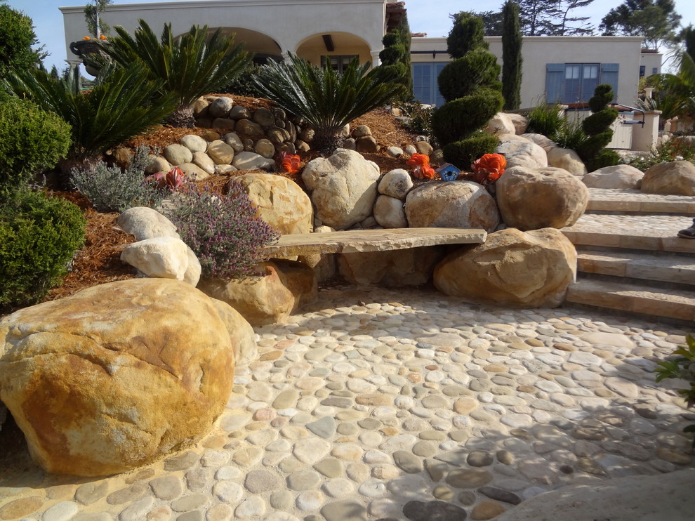 Diseño de camino de jardín mediterráneo grande en patio delantero con exposición total al sol y adoquines de piedra natural