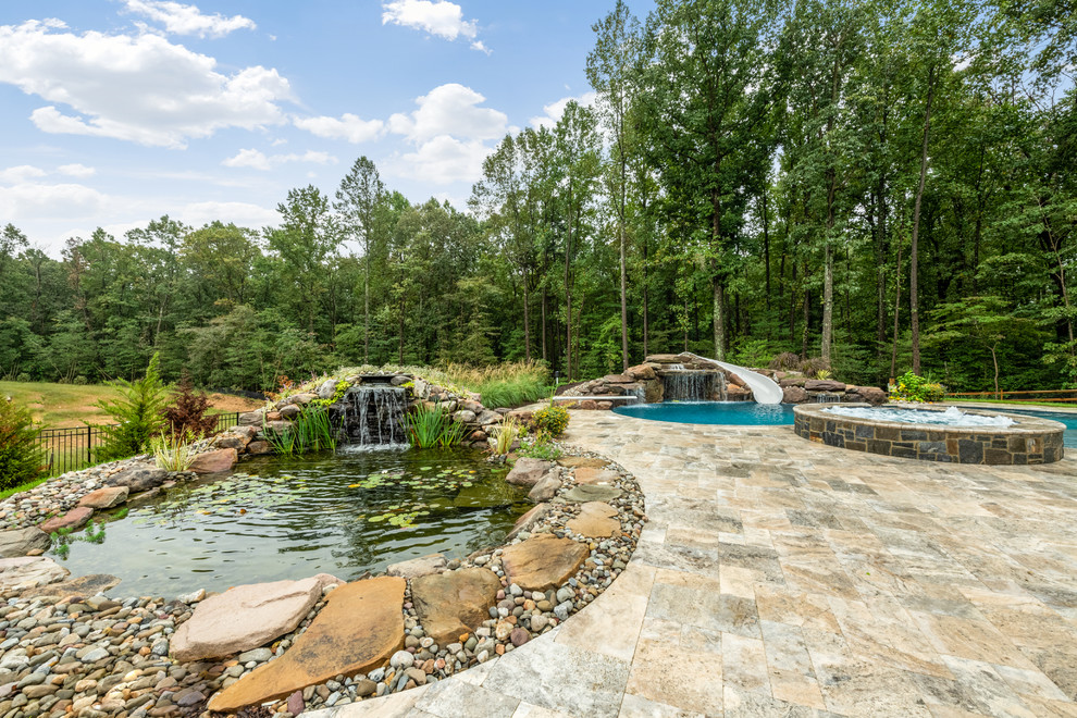 Esempio di un ampio laghetto da giardino chic esposto in pieno sole dietro casa con pavimentazioni in pietra naturale