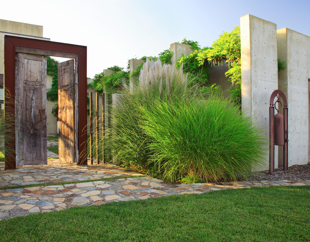 Идея дизайна: солнечный участок и сад среднего размера на заднем дворе в стиле фьюжн с хорошей освещенностью, покрытием из каменной брусчатки и забором