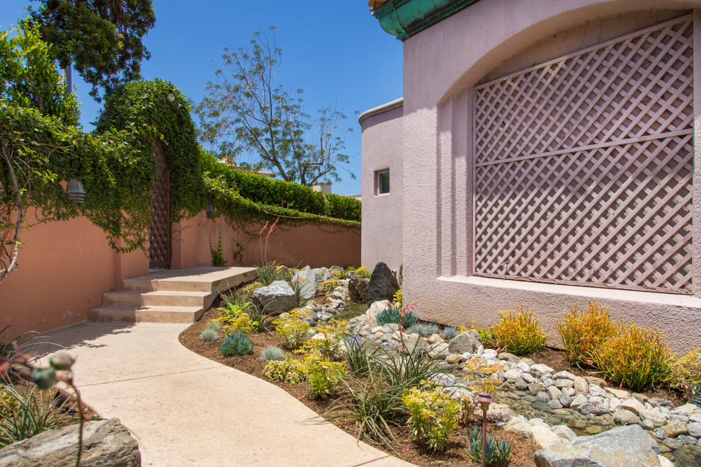 Diseño de jardín costero de tamaño medio en verano en patio con exposición parcial al sol y piedra decorativa